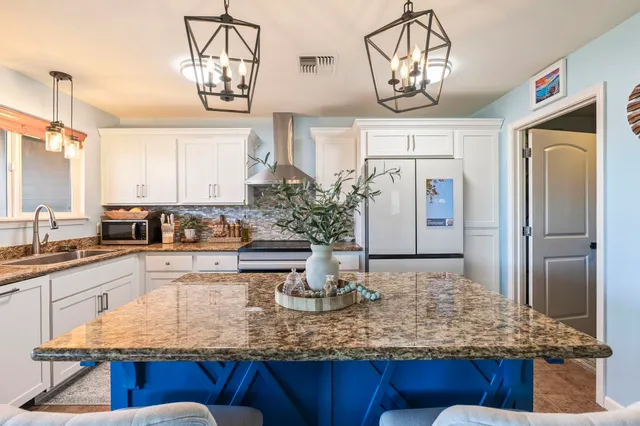 a kitchen with kitchen island granite countertop a table and chairs in it