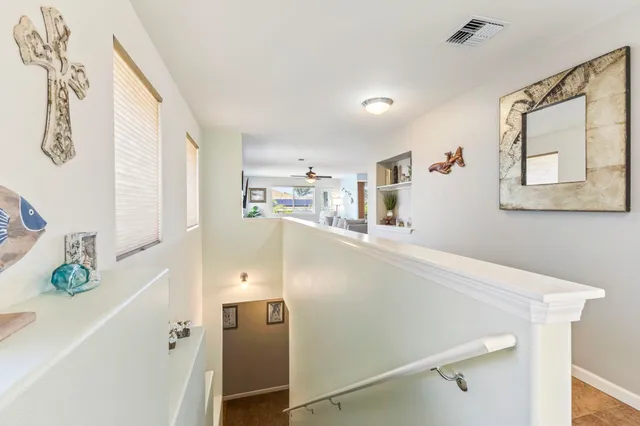 a bedroom with a bed painting on the wall and a large window