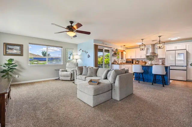 a living room with furniture and a dining table with kitchen view