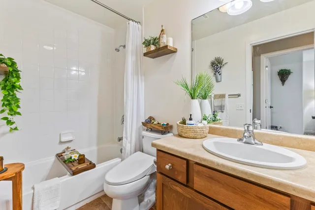 a bathroom with a granite countertop sink a toilet and a mirror