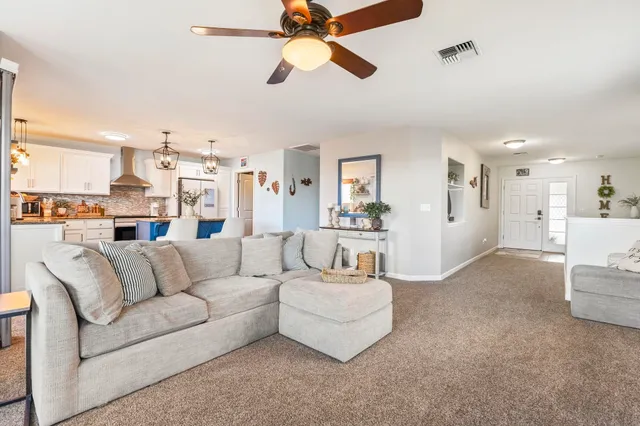 a living room with furniture and kitchen view