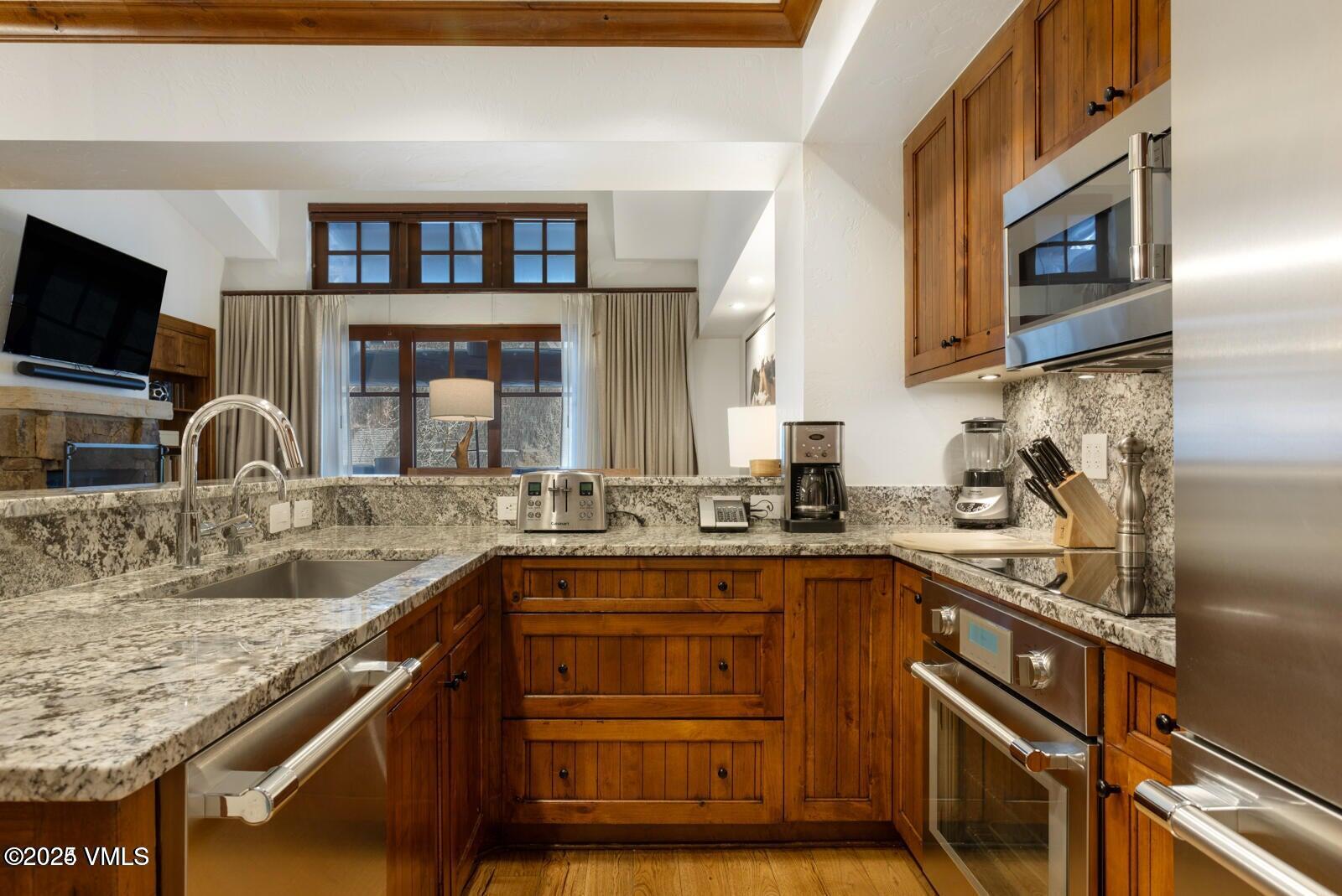 100 Bachelor Ridge Road, Unit 33146 Avon, CO 81620 - Photo 8 of 16 a kitchen with stainless steel appliances granite countertop a sink stove and cabinets