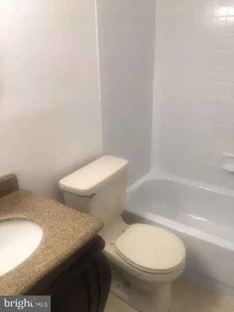 a white toilet sitting next to a bath tub and a shower