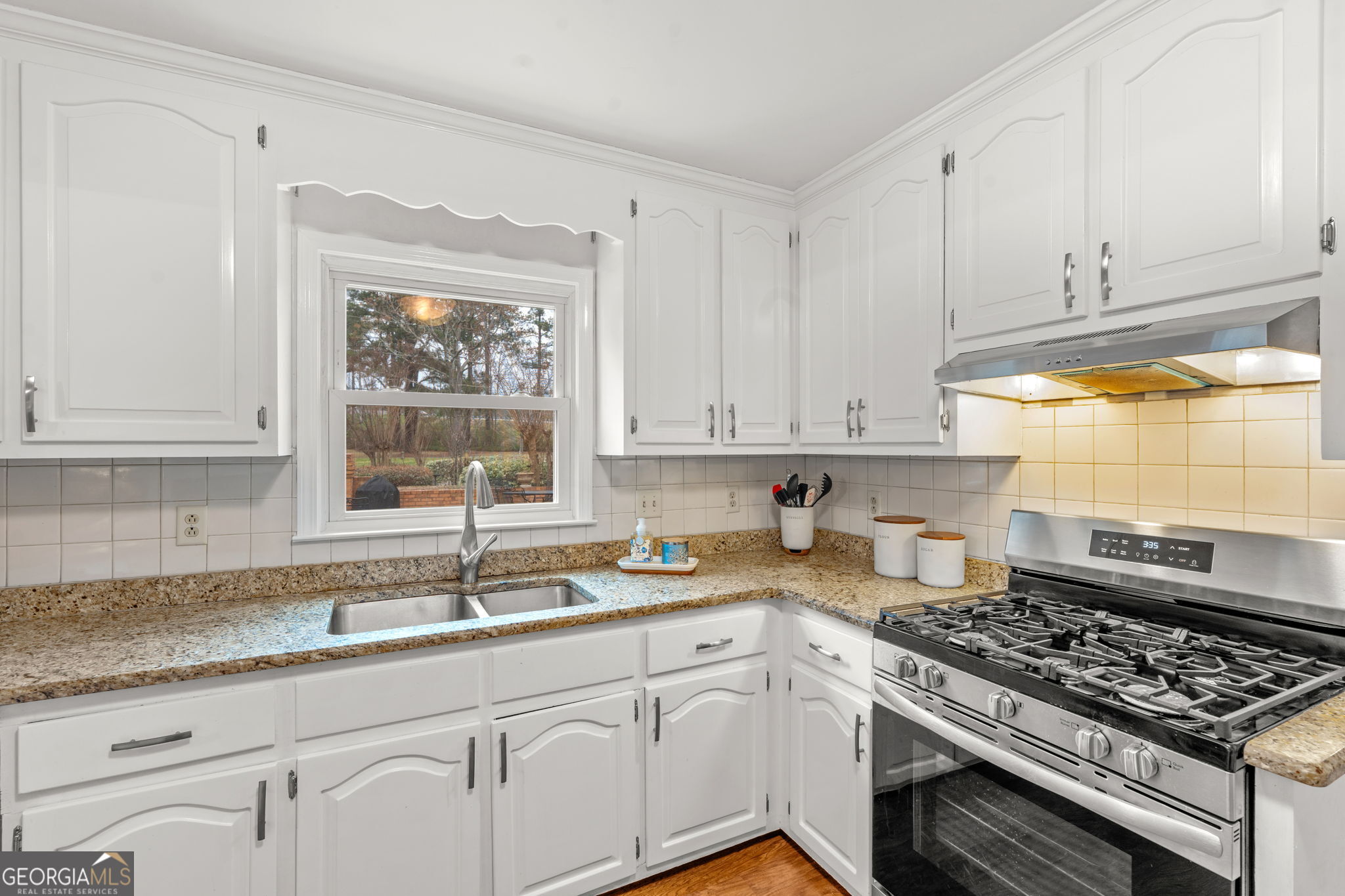 732 Bass Road Macon, GA 31210 - Photo 11 of 57 a kitchen with granite countertop white cabinets and a stove top oven