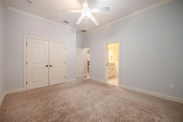 an empty room with a bathroom and a chandelier fan