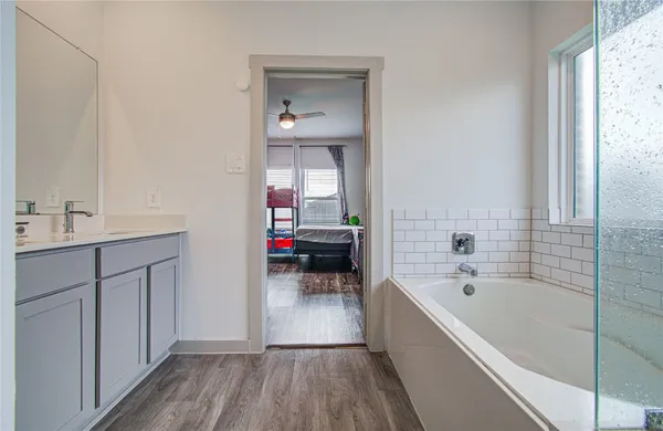a bathroom with a bathtub sink and mirror