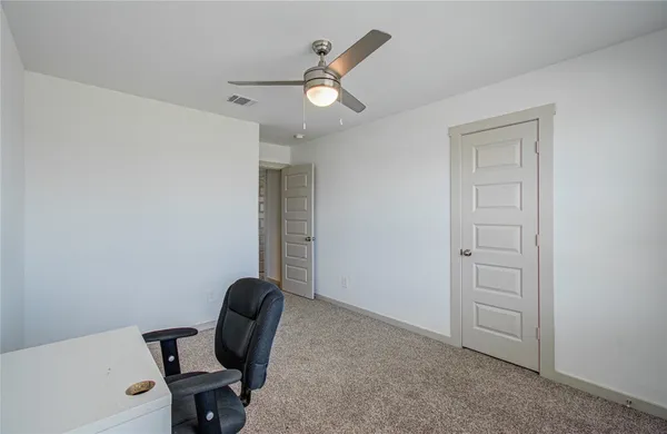 a view of workspace with chair and ceiling fan