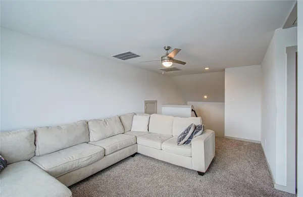 a living room with furniture and a ceiling fan