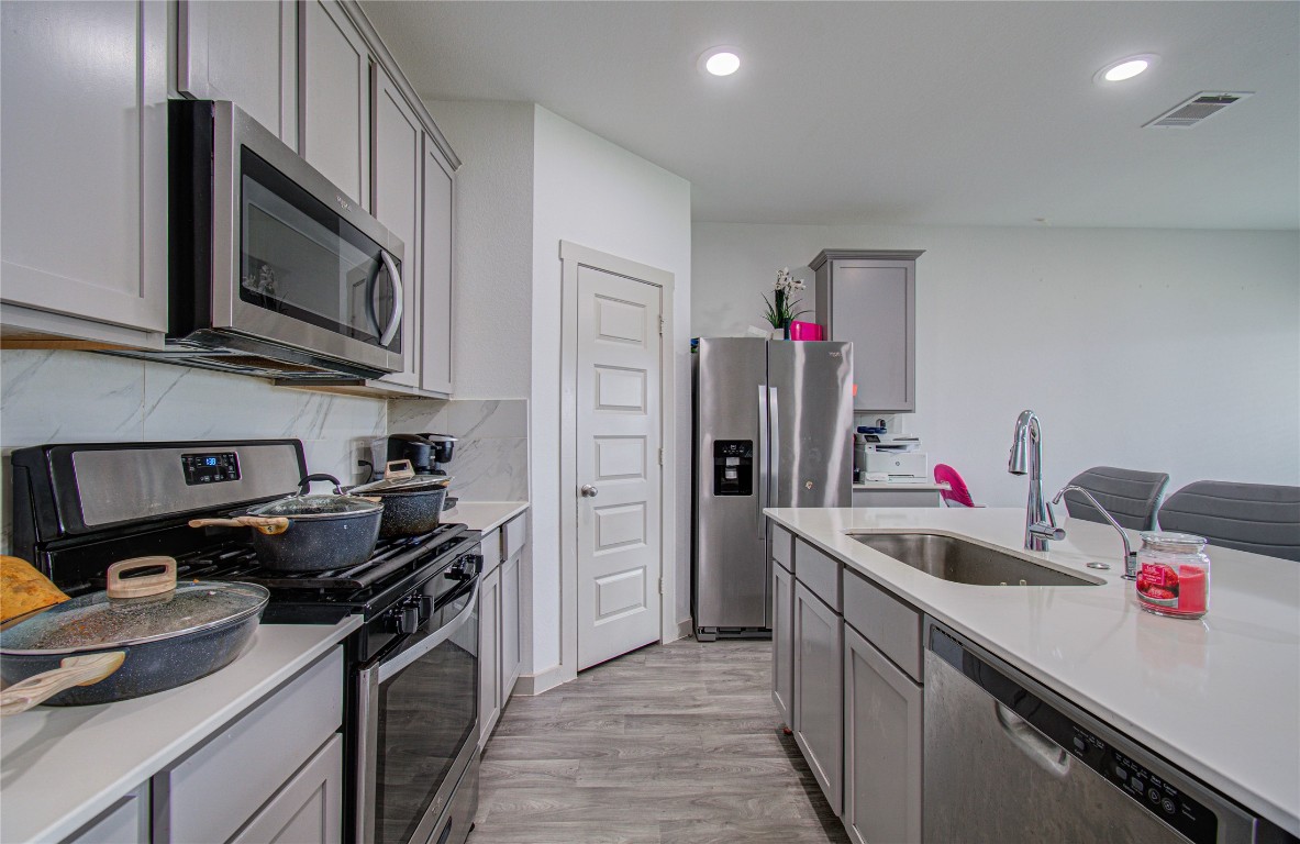 22 Desert Spring Lane Manvel, TX 77578 - Photo 6 of 36 a kitchen with stainless steel appliances a sink dishwasher a stove and a refrigerator