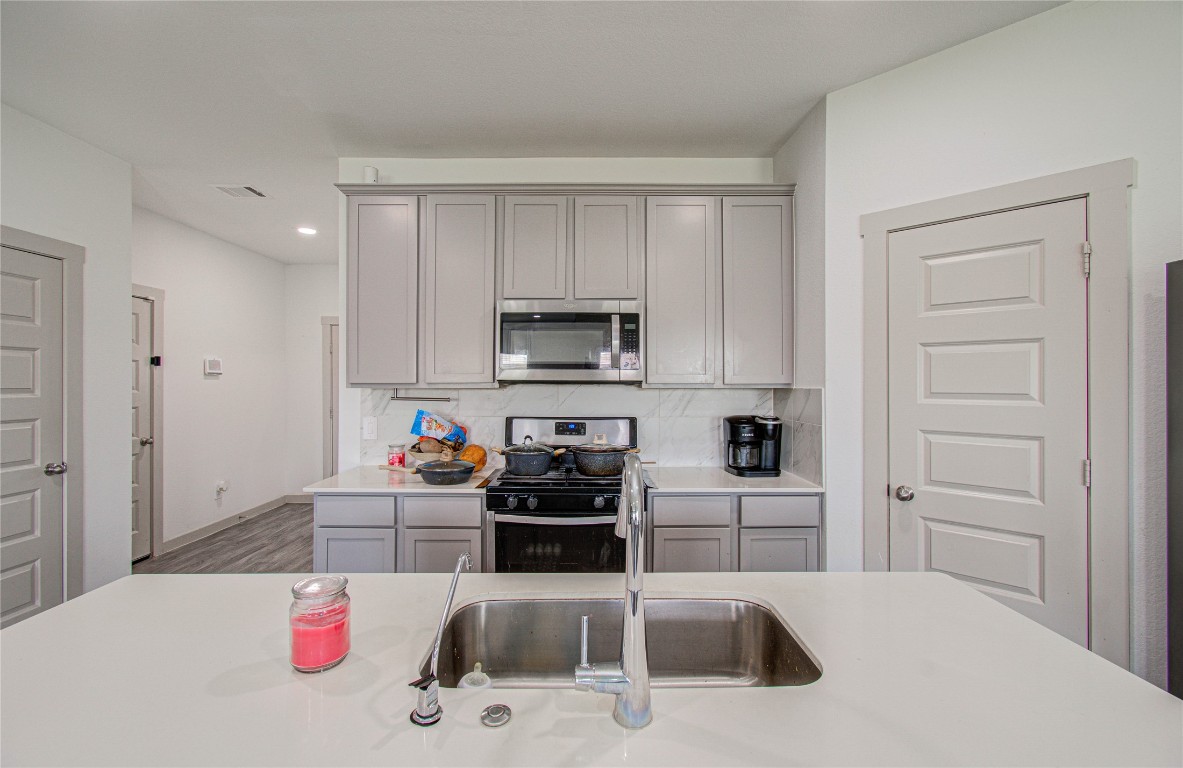 22 Desert Spring Lane Manvel, TX 77578 - Photo 7 of 36 a kitchen with white cabinets and appliances