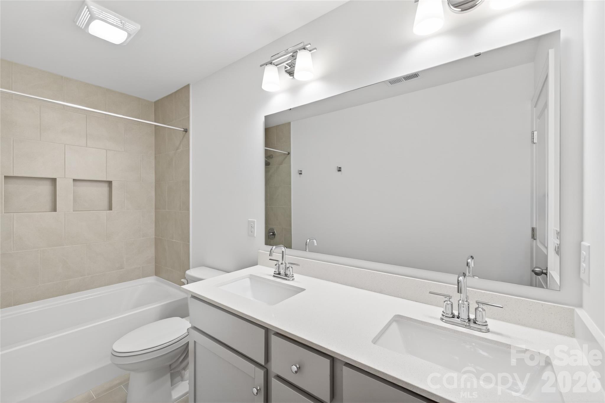 128 Overcash Road, Unit 7171 Troutman, NC 28166 - Photo 36 of 41 a bathroom with a granite countertop sink a toilet and a large mirror