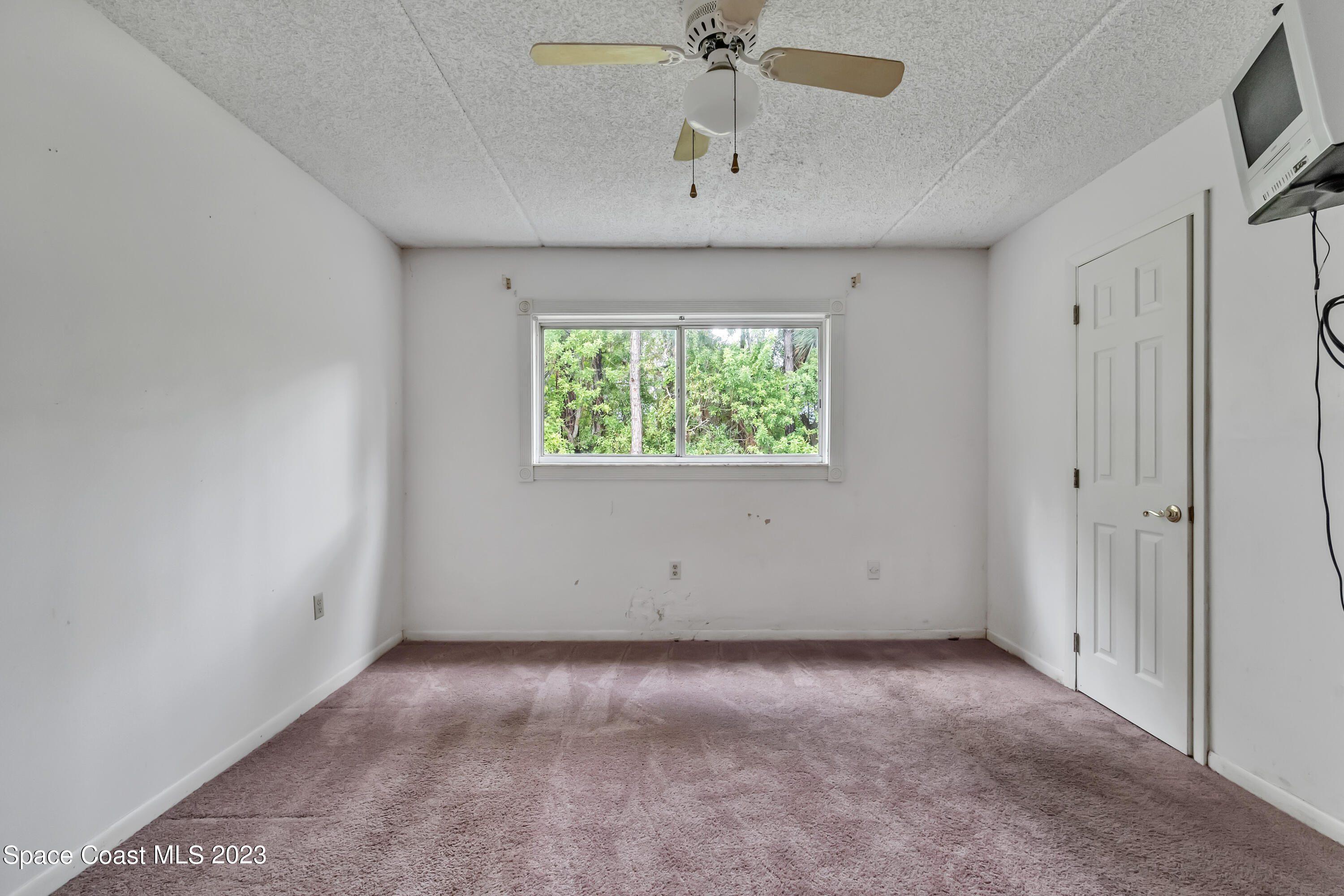 700 Ridge Club Drive, Unit 33 Melbourne, FL 32934 - Photo 13 of 32 an empty room with a window and a ceiling fan