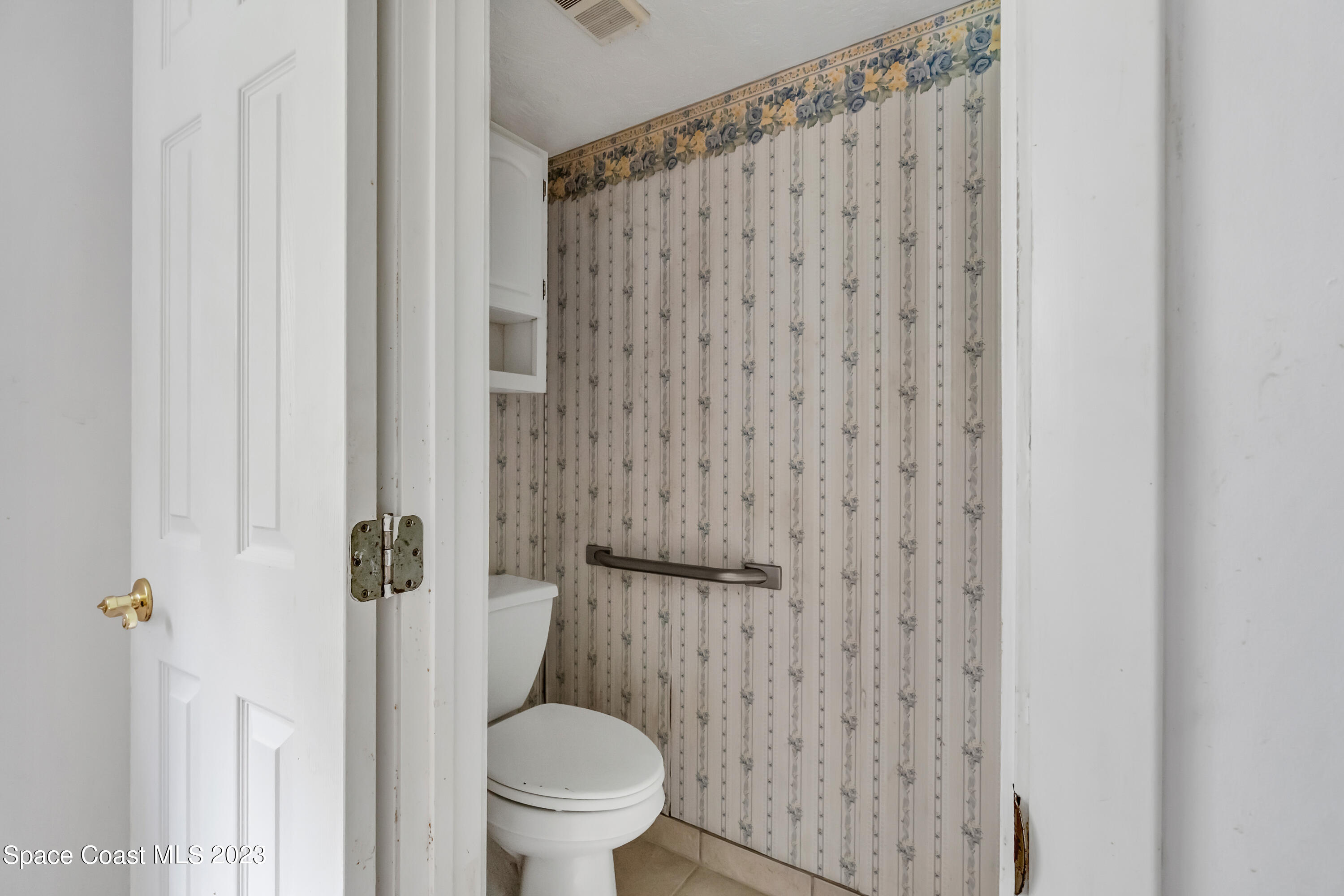 700 Ridge Club Drive, Unit 33 Melbourne, FL 32934 - Photo 18 of 32 a white toilet sitting next to a shower curtain