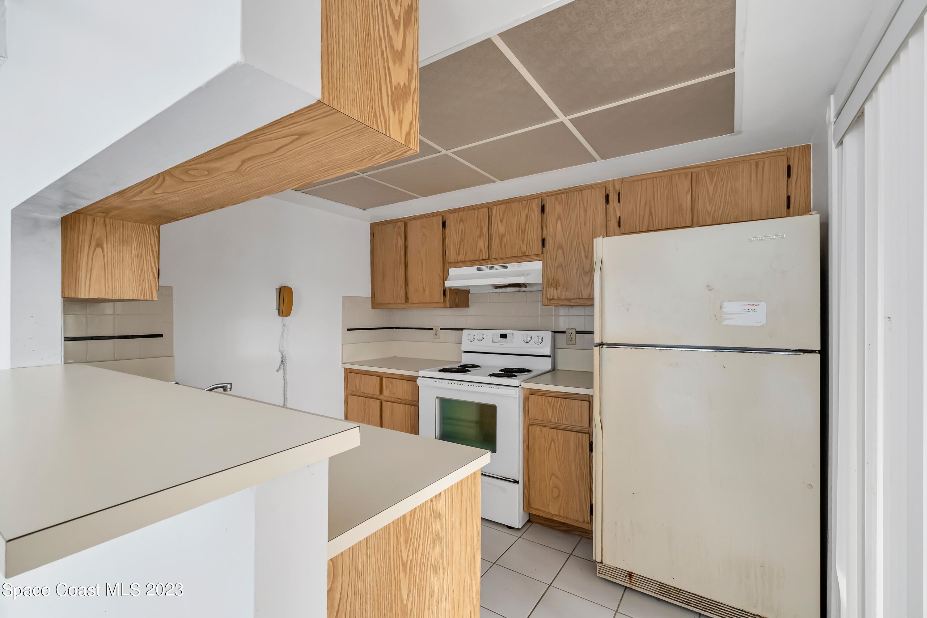 700 Ridge Club Drive, Unit 33 Melbourne, FL 32934 - Photo 4 of 32 a kitchen with a refrigerator a stove top oven a sink and cabinets