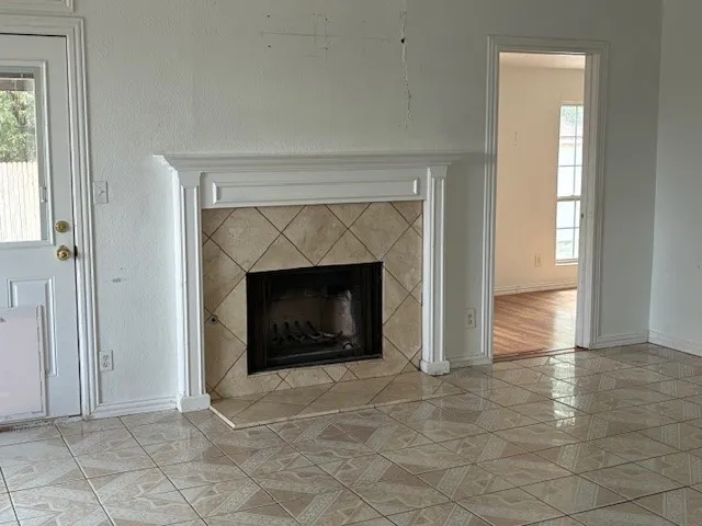 a view of an empty room with window and fire place