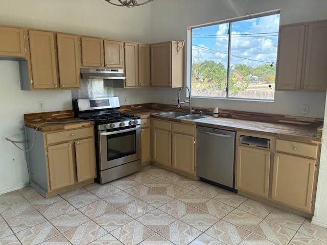 a kitchen with a stove sink and cabinets