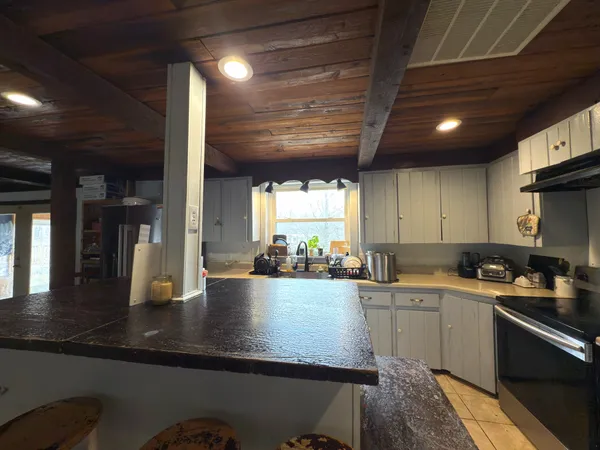 a kitchen with stainless steel appliances granite countertop a sink a stove and a refrigerator