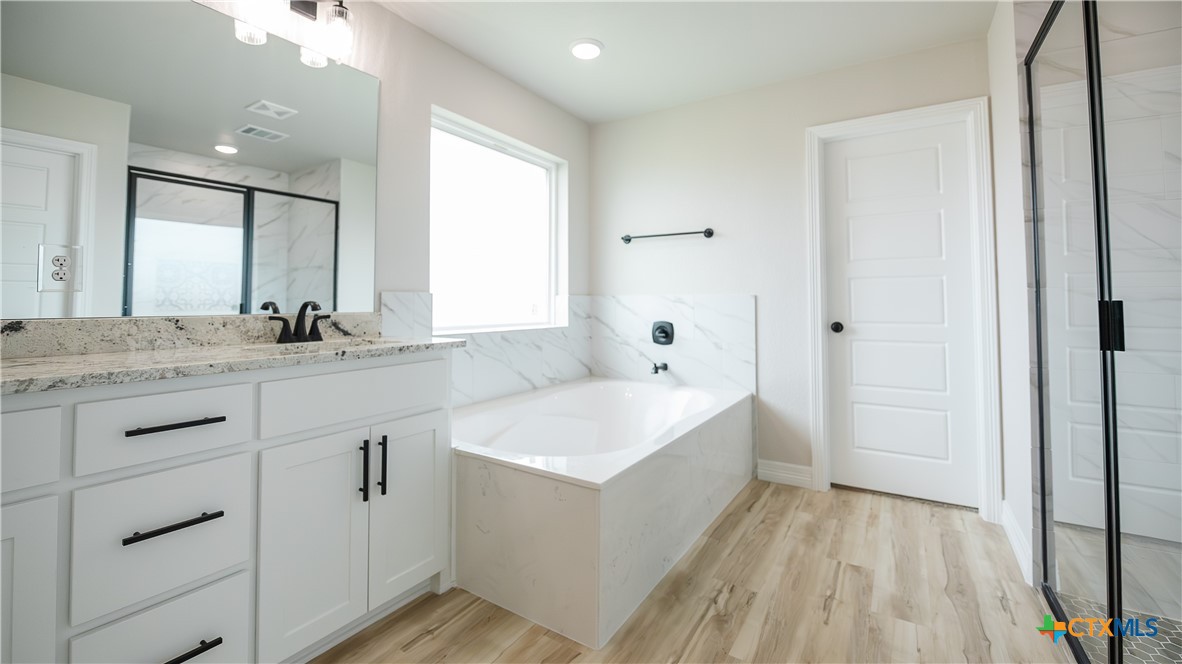 1404 Tahonta Drive Hewitt, TX 76643 - Photo 15 of 32 a bathroom with a sink a mirror and a bathtub