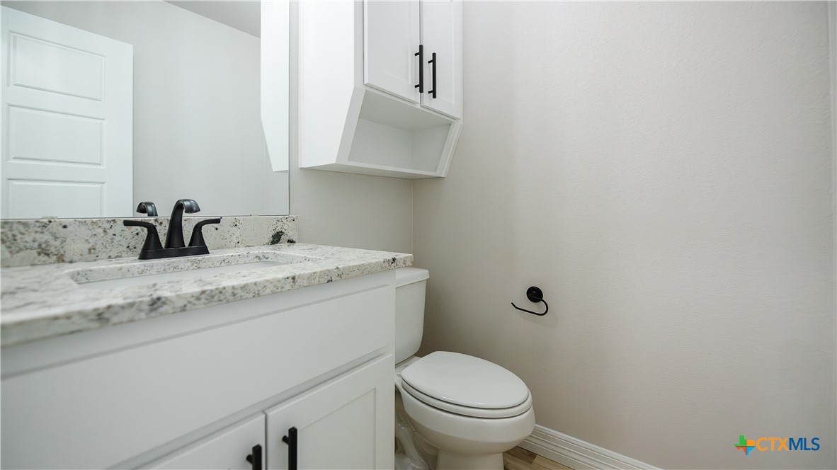 1404 Tahonta Drive Hewitt, TX 76643 - Photo 18 of 32 a bathroom with a granite countertop toilet sink and mirror