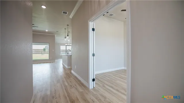 a view of a hallway with wooden floor