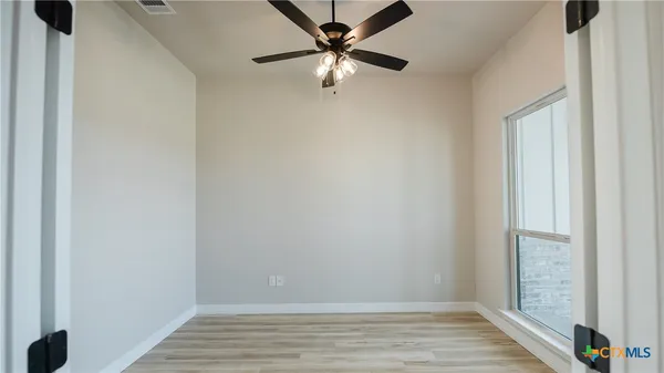 a view of an empty room with wooden floor