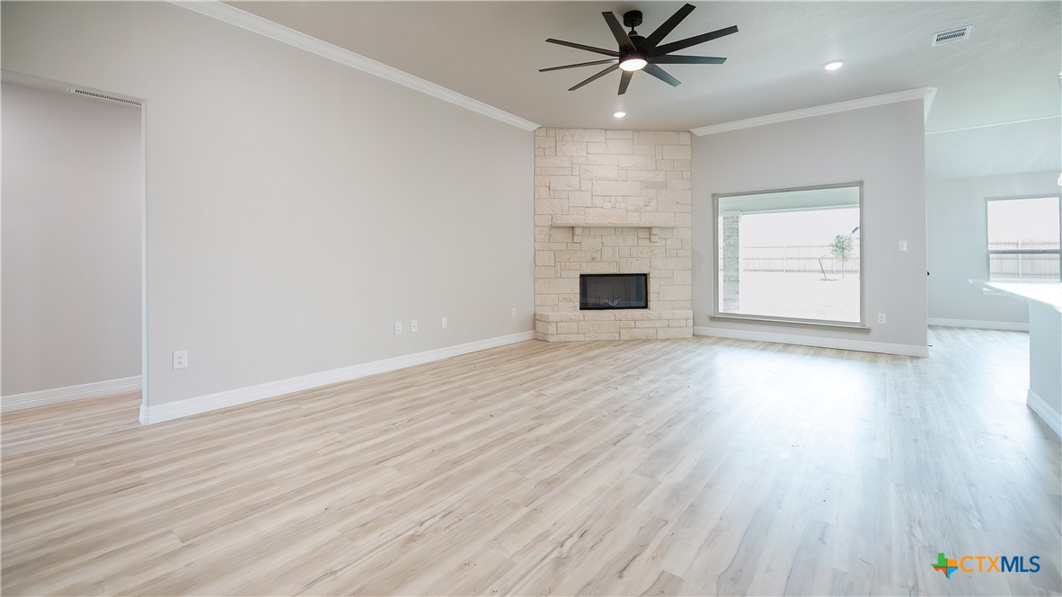 1404 Tahonta Drive Hewitt, TX 76643 - Photo 8 of 32 an empty room with wooden floor windows and ceiling fan