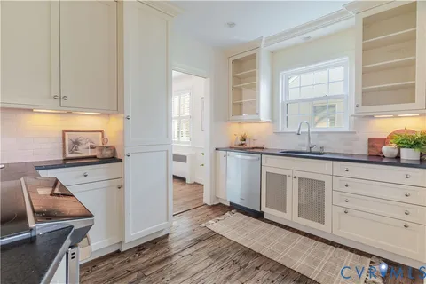a kitchen with granite countertop white cabinets and white appliances