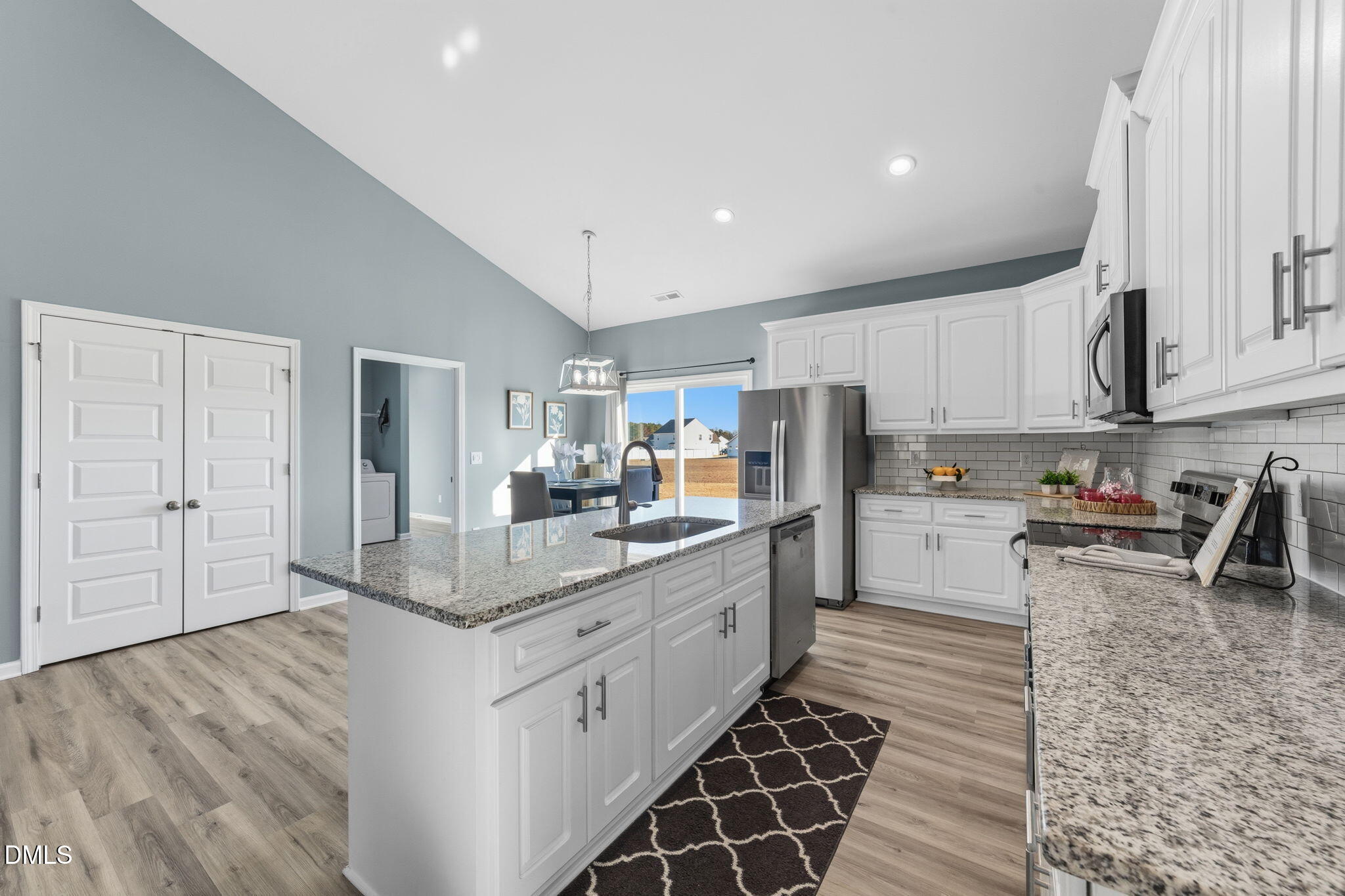 4029 Needham Road Bailey, NC 27807 - Photo 9 of 21 a kitchen with stainless steel appliances kitchen island granite countertop a refrigerator oven a sink dishwasher and white cabinets with wooden floor