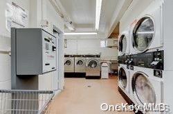 99-10 60th Avenue, Unit 5L Queens, NY 11368 - Photo 11 of 13 a view of washer and dryer with kitchen in the background