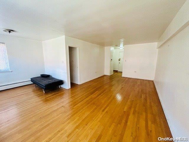 99-10 60th Avenue, Unit 5L Queens, NY 11368 - Photo 5 of 13 an empty room with wooden floor and a window