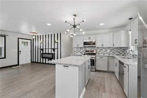 a kitchen with stainless steel appliances granite countertop a stove cabinets and a refrigerator