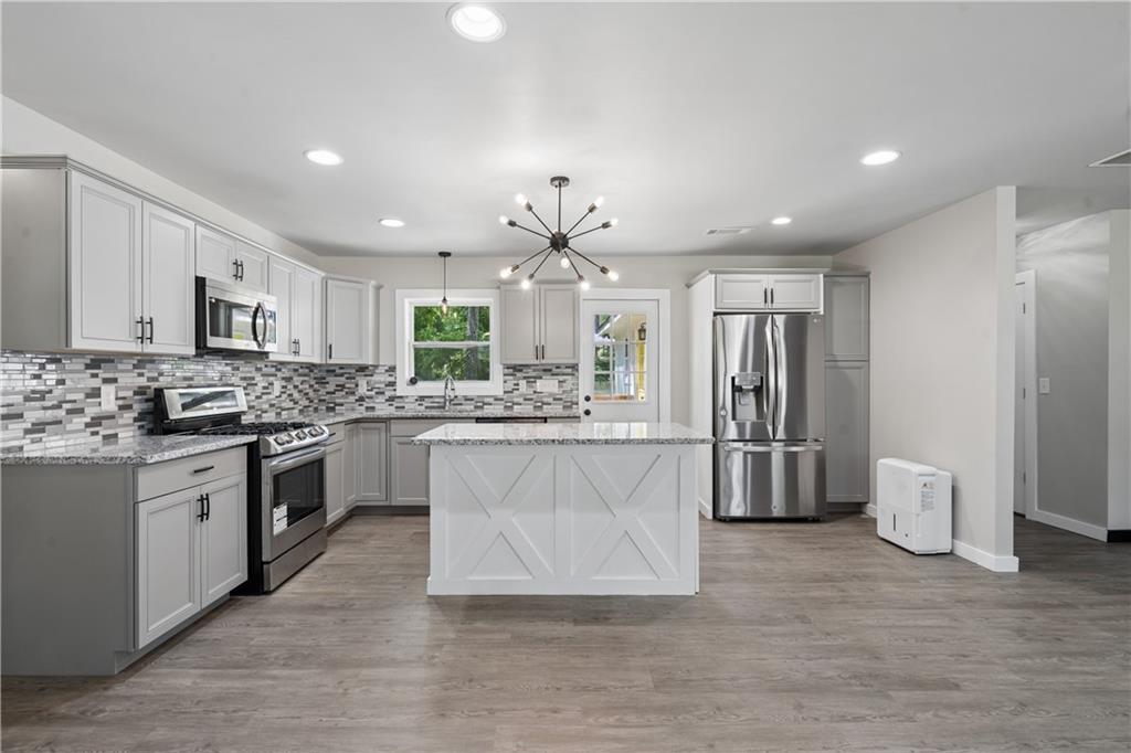 2357 Scotty Circle Decatur, GA 30032 - Photo 12 of 44 a large kitchen with stainless steel appliances kitchen island granite countertop a refrigerator and a stove top oven