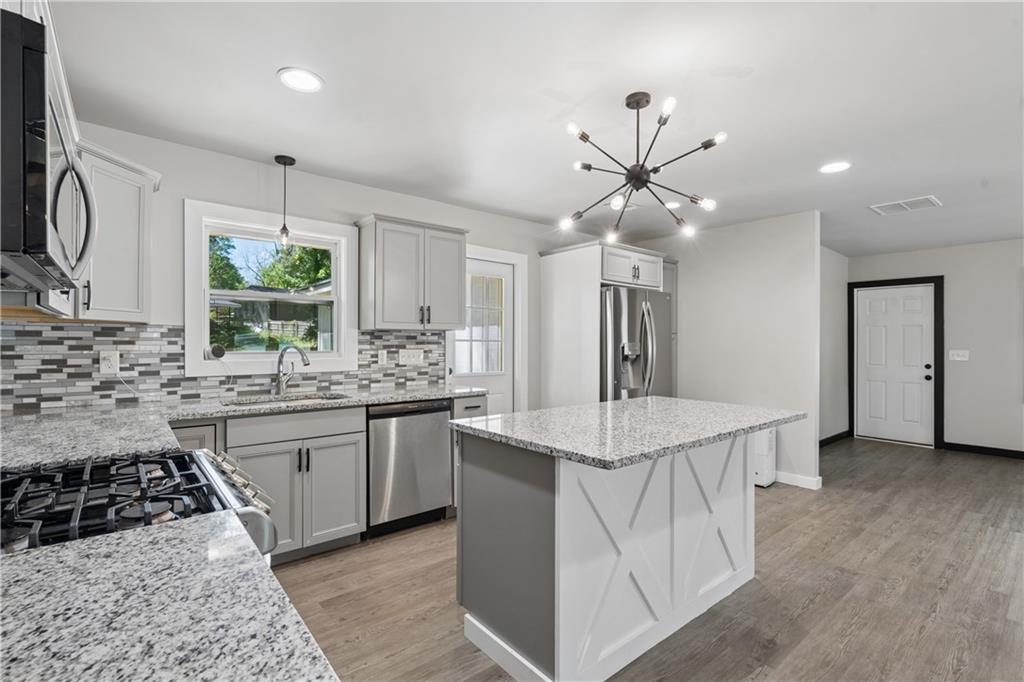2357 Scotty Circle Decatur, GA 30032 - Photo 15 of 44 a kitchen with stainless steel appliances a white stove top oven a sink a counter space and cabinets