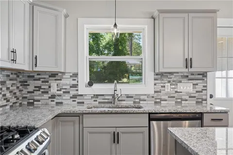 a kitchen with granite countertop a sink and a window