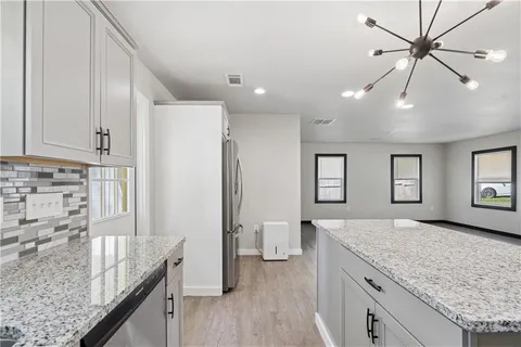 a spacious bathroom with a granite countertop sink and a refrigerator