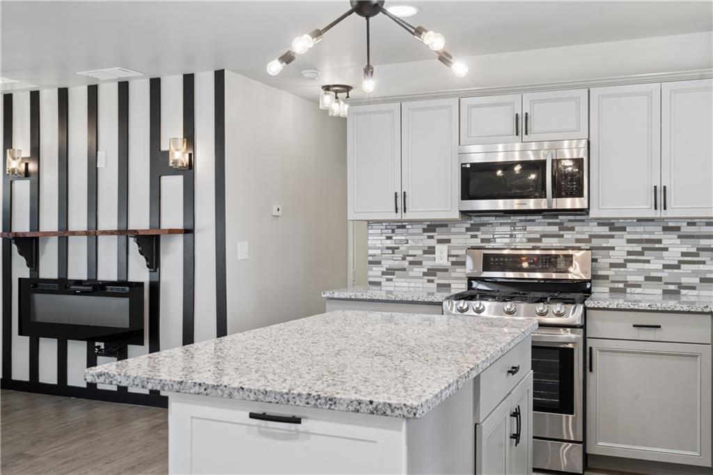 2357 Scotty Circle Decatur, GA 30032 - Photo 23 of 44 a kitchen with kitchen island granite countertop a stove sink and microwave