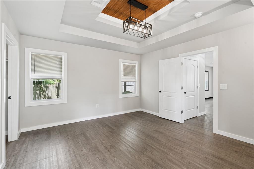 2357 Scotty Circle Decatur, GA 30032 - Photo 27 of 44 an empty room with wooden floor chandelier fan and windows