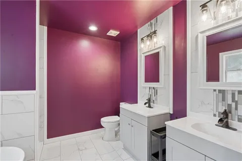 a bathroom with a sink vanity mirror and toilet