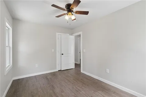 a view of a room with wooden floor and a ceiling fan
