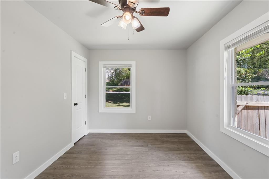 2357 Scotty Circle Decatur, GA 30032 - Photo 35 of 44 an empty room with wooden floor chandelier fan and windows
