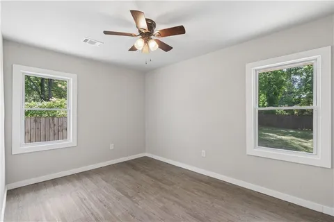 a view of a big room with wooden floor and windows