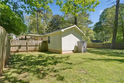 a view of a house with a yard and fence