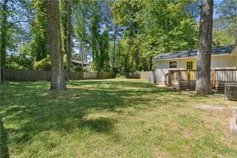 a backyard of a house with barbeque oven and trees
