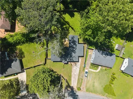 an aerial view of residential house with outdoor space and trees all around