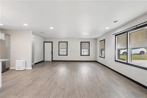 a view of a big room with wooden floor and windows