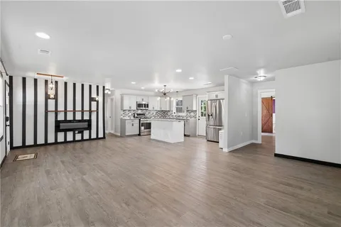 a view of a kitchen with stainless steel appliances wooden floor and a large window