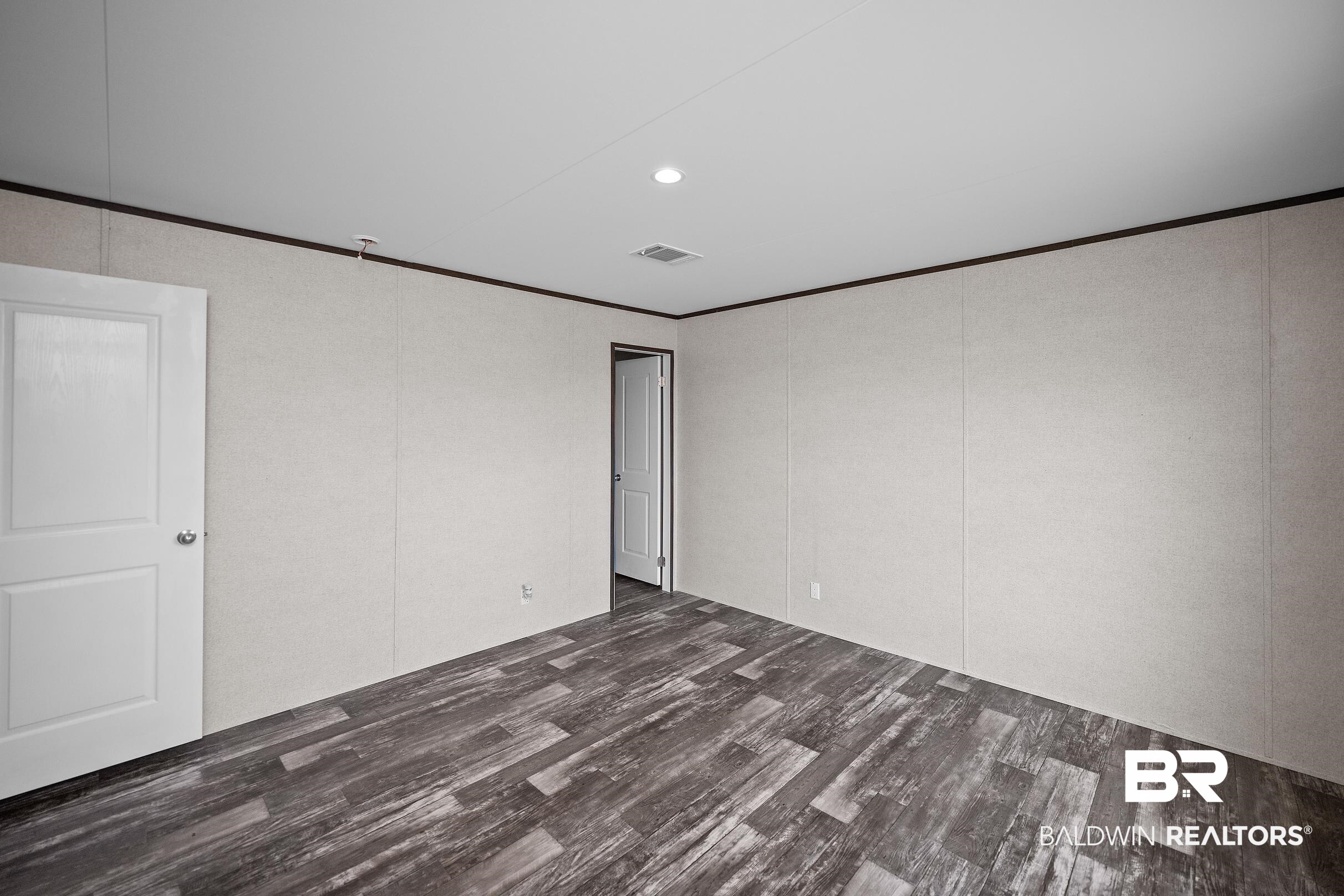 21601 Westside Loop Silverhill, AL 36576 - Photo 37 of 42 Spacious room featuring wood-finish flooring, light-colored walls, and a recessed ceiling light