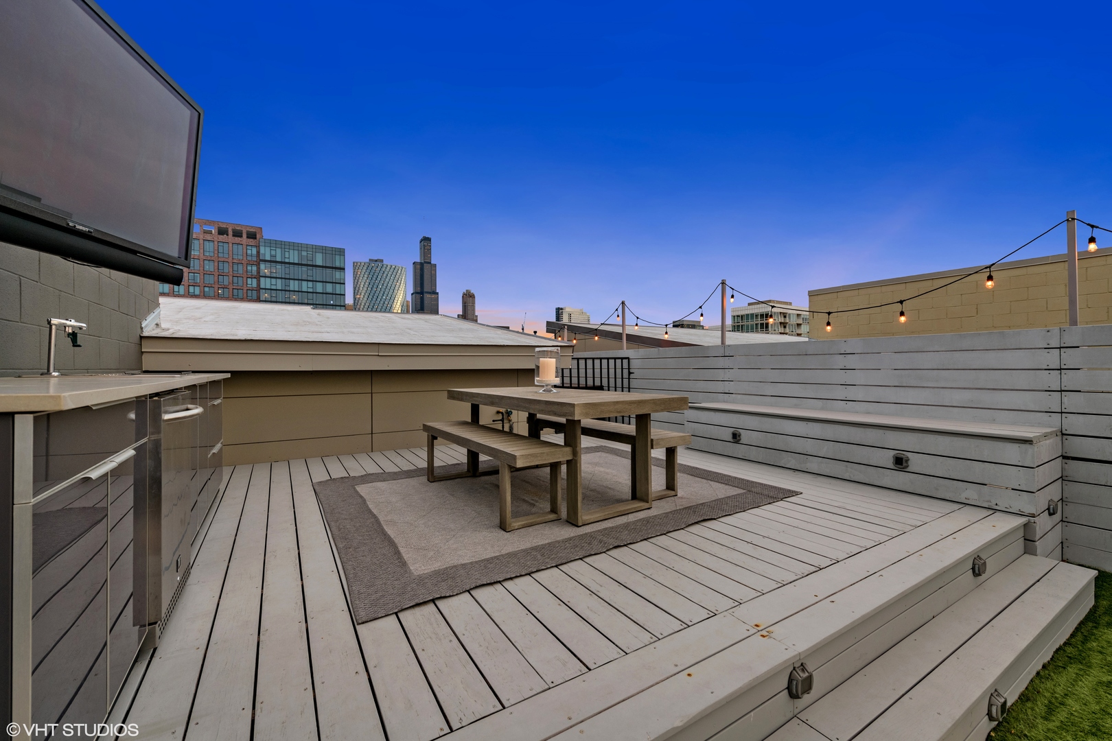 18 North Carpenter Street, Unit PHS Chicago, IL 60607 - Photo 26 of 33 a view of a roof deck with dining table and chairs with wooden floor and fence