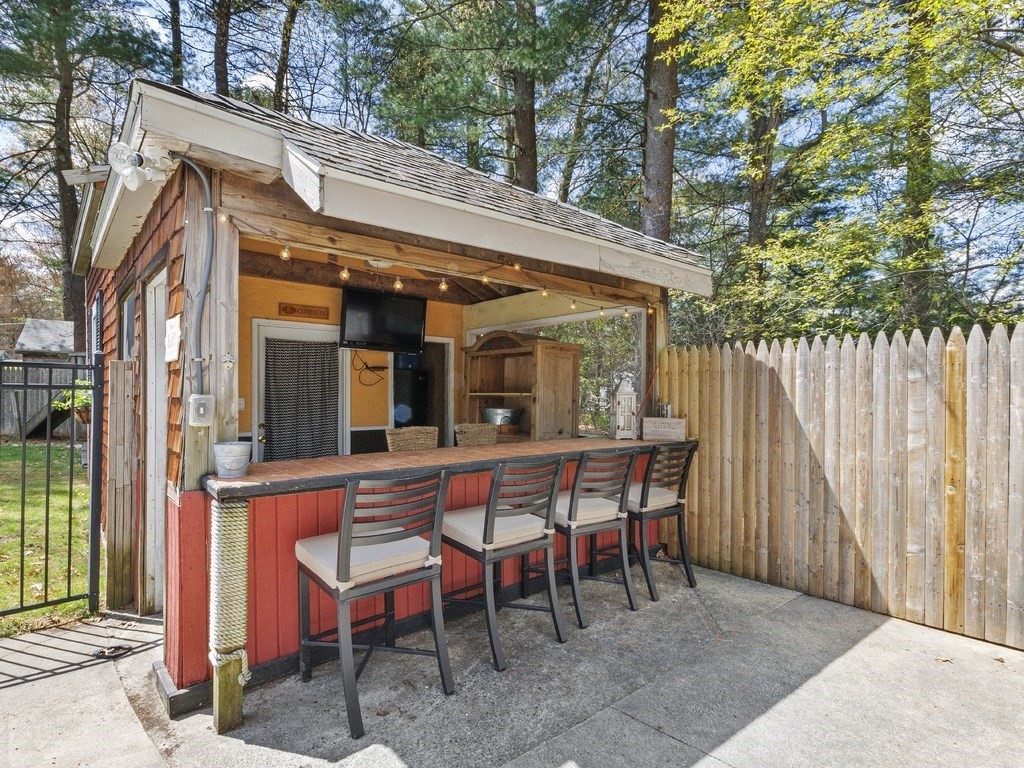 435 Old Post Road Walpole, MA 02081 - Photo 28 of 36 a view of a patio with table and chairs with wooden fence and large trees