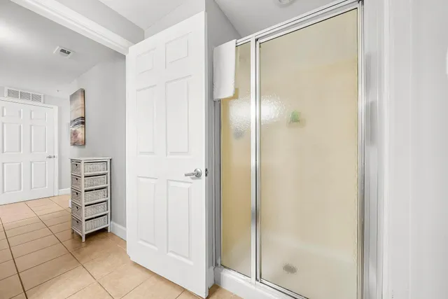 a kitchen that has a lot of white cabinets and stainless steel appliances
